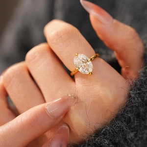 Close-up of an 18k gold-plated oval zircon ring with a four-prong setting on a hand