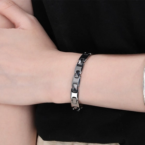 Detailed view of a sleek black tungsten link bracelet with diamond-cut geometric texture