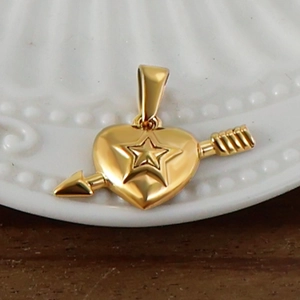 Détail d'un pendentif cœur doré avec gravure d'étoile et flèche sur une assiette en céramique