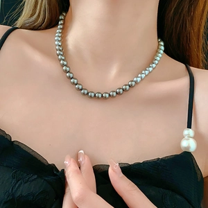 Close-up of elegant grey pearl necklace on model neck featuring metallic luster