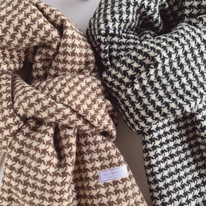 Detailed macro shot of classic houndstooth patterns on thick wool blended scarves