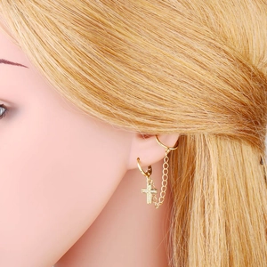 Detailaufnahme goldener Kreuzanhänger-Ohrring mit Gliederkette und Manschette für Damen