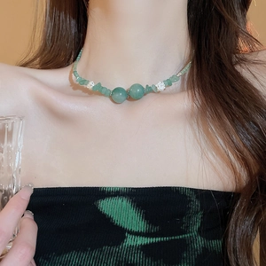 Dettaglio della collana di perline verdi con distanziatori a forma di fiore