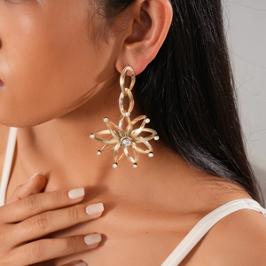Detail of gold starburst earrings with diamonds on a model for a stylish look