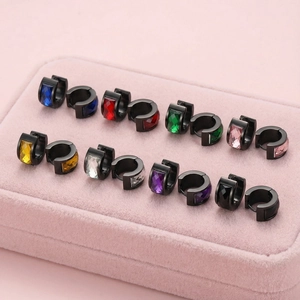 Close-up of colorful round zircon huggie earrings arranged in a pink velvet jewelry box