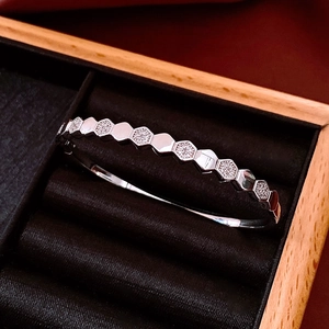 Macro shot of silver hexagon honeycomb bracelet with pavé set zircon in jewelry box