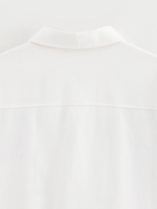 Detail of white denim jacket featuring high-quality twill texture and collar stitching