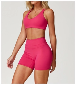 Détail d'un ensemble de yoga magenta avec soutien-gorge col en V et short à taille haute