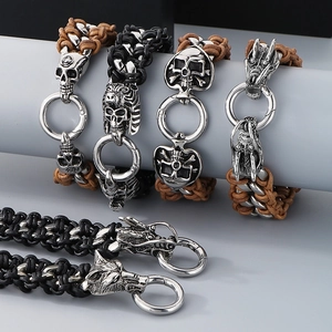 Close-up of punk style skulls and wolf head charms on woven leather bracelets for men