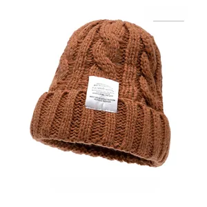 Detailed close-up of thick coffee knit texture and decorative label on the winter beanie