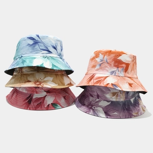 Flat lay view of six floral sun hats in various colorful patterns and vivid colors