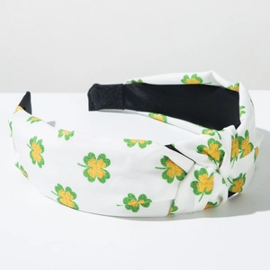 Detail of the white knotted headband featuring green clover patterns and textured fabric