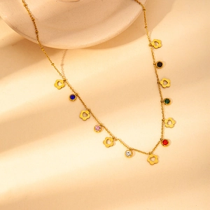 Close-up of gold chain necklace featuring multi-colored gemstones and floral heart pendant