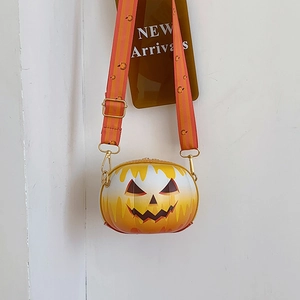 Detail of pumpkin-shaped crossbody bag with jack-o'-lantern face and striped wide strap