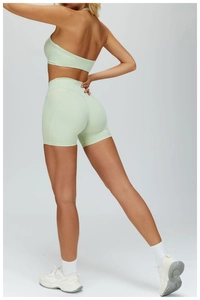 Dettaglio degli shorts da yoga verde menta a vita alta con effetto scrunch per sollevamento