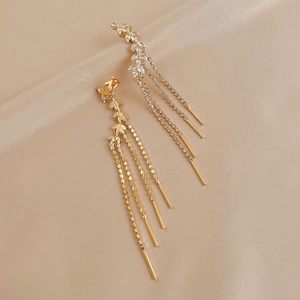 Macro shot of elegant leaf-shaped zircon earrings with long multilayer chain tassels