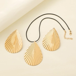 Golden drop necklace and earrings set with pleated texture on minimalist background
