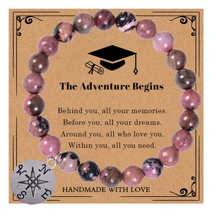 Detail of pink rhodonite beaded bracelet with compass charm on adventure gift card
