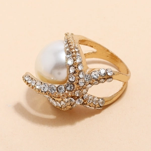 Gold starfish ring featuring a large white pearl and pavé crystals on a minimalist band