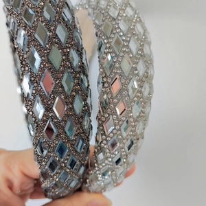 Close-up of sparkling rhinestone headbands in grey and silver with grid pattern texture