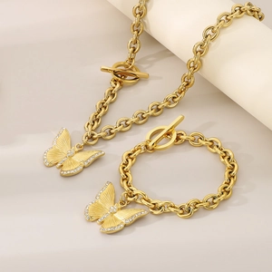 Makroaufnahme goldener Schmetterlingsanhänger mit Kristallverzierung an dicken Ketten