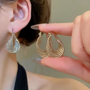 Textured hollow twisted oval hoop earrings in gold and silver metal finishes