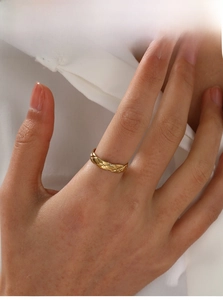 Detailed view of an 18K gold-plated stainless steel ring featuring a quilted motif design