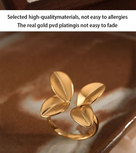 Macro shot of gold-plated leaf-shaped open ring showing intricate petal design and texture