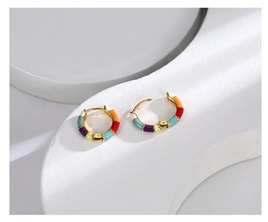 Detail view of colorful rainbow enamel earrings with polished gold-tone bamboo pattern