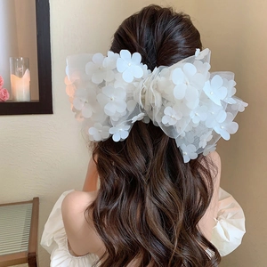 Elegant oversized white 3D mesh flower hair bow with pearls on long wavy hair