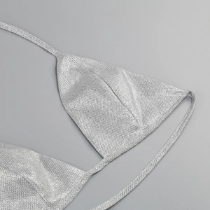 Close-up of silver sequin triangle bikini top with metallic texture and tie straps