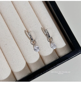 Detail of S925 sterling silver hoop earrings with pear-cut cubic zirconia pendants