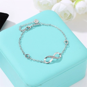 Close-up of S925 silver infinity bracelet with diamonds and heart clasp in gift box