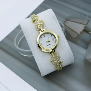 Detailed macro view of crystal-encrusted gold watch strap with elegant heart hollow design
