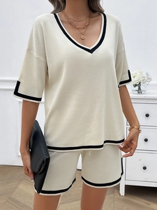 Detail of knit casual lounge set with V-neck top and shorts featuring black contrast piping
