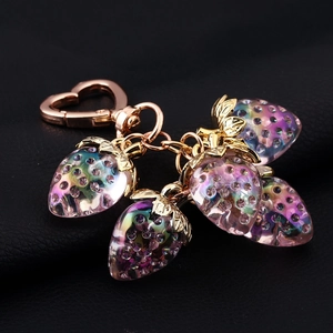 Detailed close-up of sparkling crystal strawberry pendants on a gold keychain