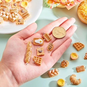 Miniature resin food pendants including bread and waffles with a coin for scale