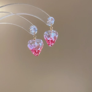 Macro detail of strawberry earrings featuring pink resin gradient and sparkling cubic zirconia