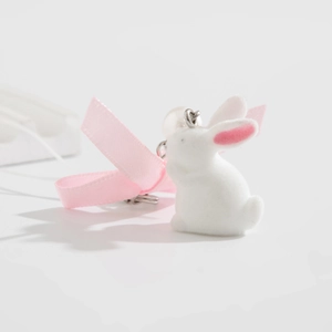 Detail of white flocked bunny keychain with pink bow and elegant pearl accent