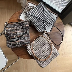Close-up of vintage tweed crossbody bags in striped patterns with slim leather straps