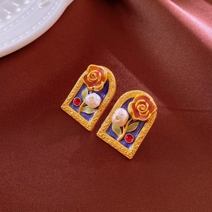 Detail of vintage palace style earrings with red rose, blue enamel and baroque pearl