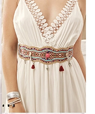 Close-up of Bohemian embroidered waist belt with red tassels and silver bell details