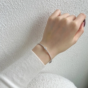 Detailed close-up of a silver geometric bracelet featuring micro-pave diamonds and a rectangular stone