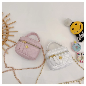 Detail of pink and white quilted crossbody bags for girls with gold chain and flower hardware