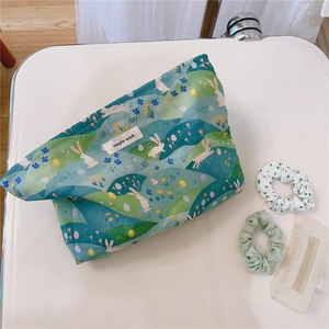 Detail of floral cotton makeup bag with rabbit prints and hair accessories layout