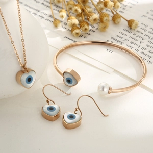 Elegant rose gold evil eye jewelry set with necklace, pearl bracelet, and heart earrings