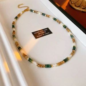 Macro view of aquamarine and pearl beaded necklace with 925 silver lobster clasp