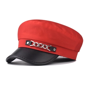 Détail d'une casquette militaire rouge avec visière en cuir noir et chaîne argent