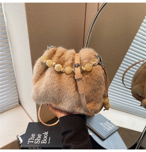 Close-up of plush faux fur bucket bag featuring beaded handle and adjustable strap