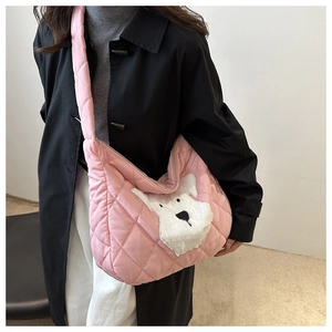 Detail of pink quilted crossbody bag featuring a cute white terrier plush patch